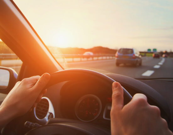 hands of car driver on steering wheel, road trip, driving on highway road