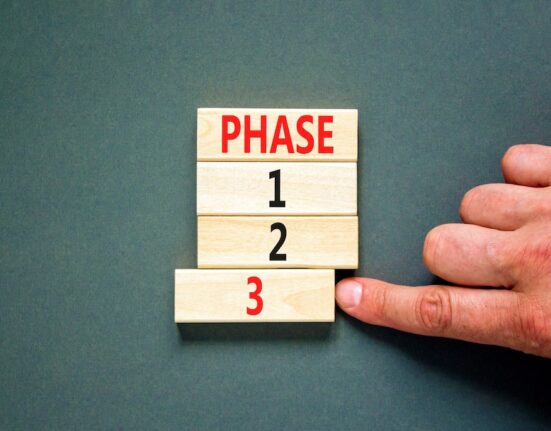 Time to phase 3 symbol. Concept word Phase 1 2 3 on wooden block. Businessman hand. Beautiful grey table grey background. Business planning and time to phase 3 concept. Copy space.