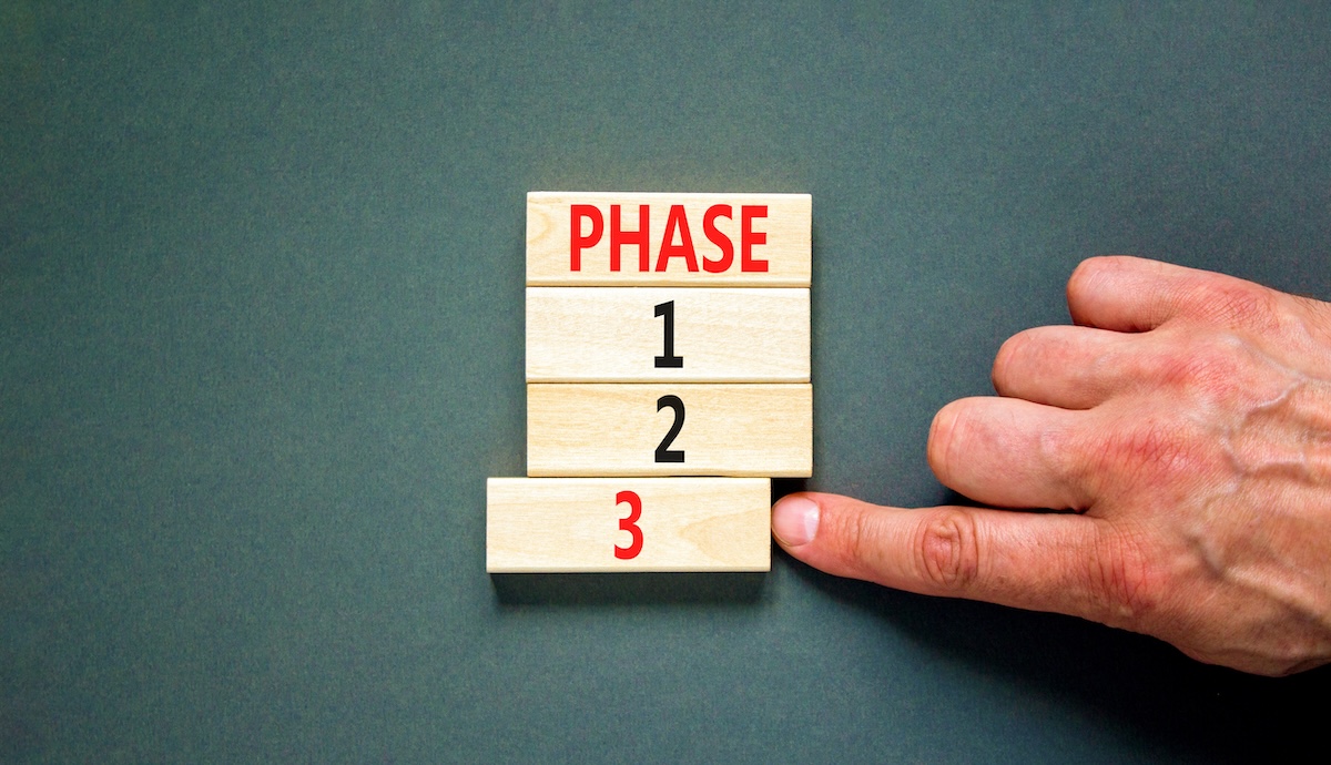 Time to phase 3 symbol. Concept word Phase 1 2 3 on wooden block. Businessman hand. Beautiful grey table grey background. Business planning and time to phase 3 concept. Copy space.