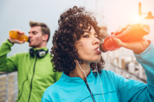Sporty runners couple drinking energy drink
