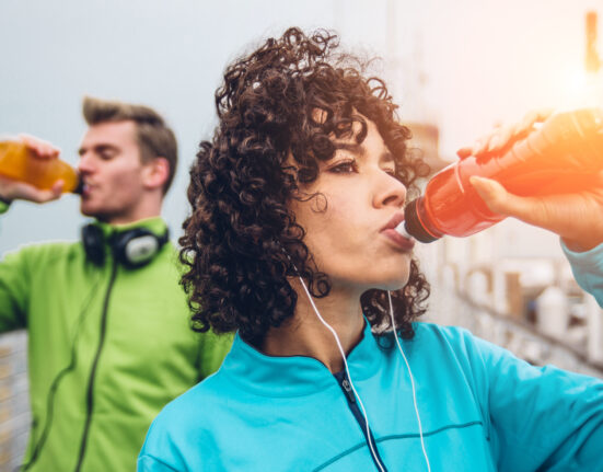 Sporty runners couple drinking energy drink
