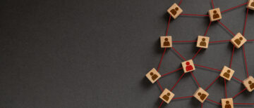 Organization structure, social network and teamwork concept on dark background. Business people icon on wooden cube blocks connecting network of connections.