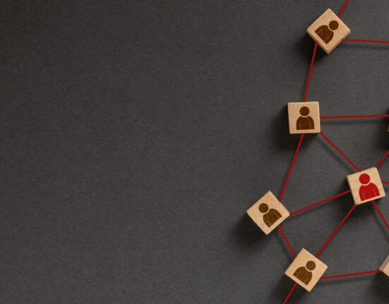 Organization structure, social network and teamwork concept on dark background. Business people icon on wooden cube blocks connecting network of connections.