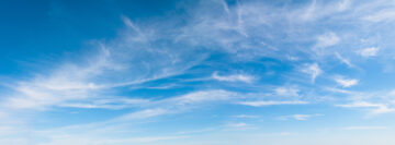 Beautiful Bright Blue sky with white clouds over the horizon in sunny windy day. Wide Angle Nature sky background, texture for Design. Natural Panoramic cloudy Wallpaper or Web banner With Copy Space