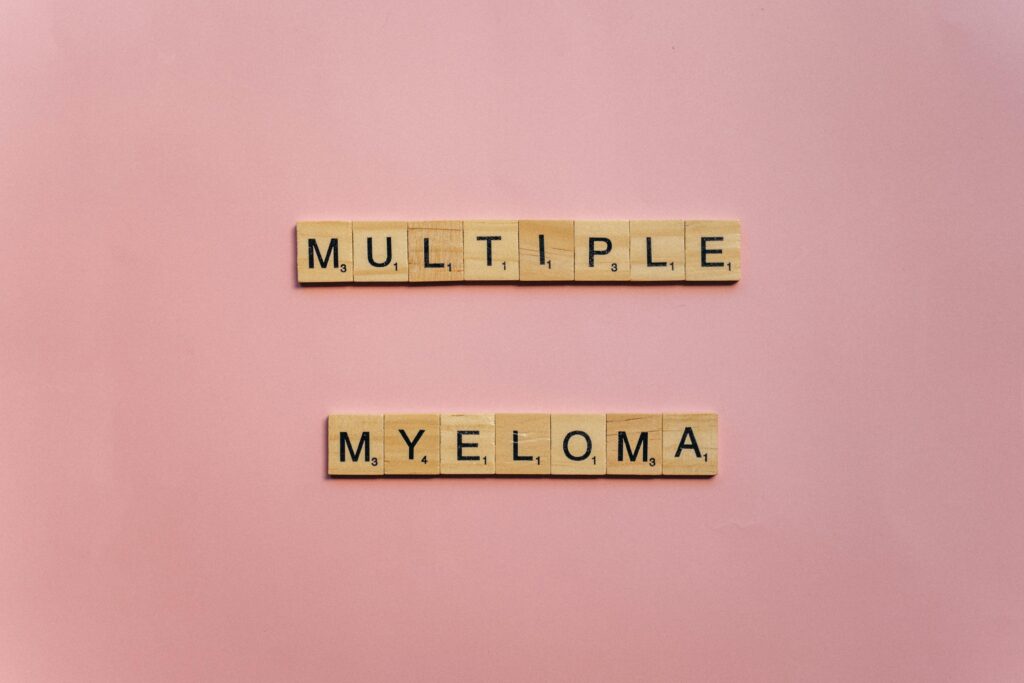 pink back ground , multiple myeloma spelled out in wooden blocks