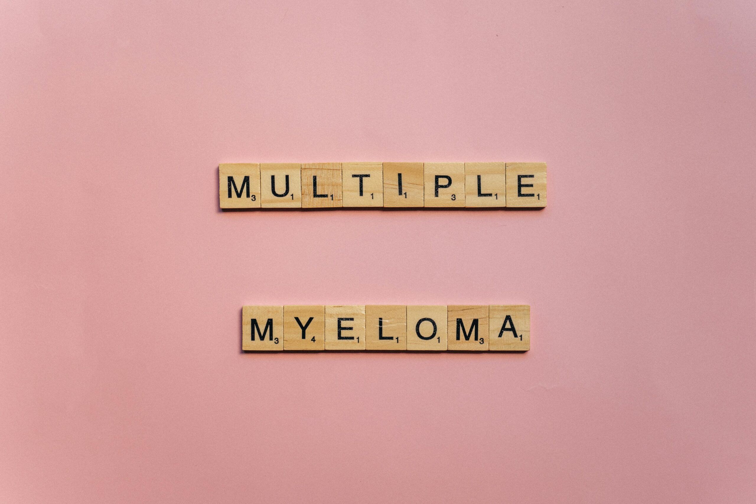 pink back ground , multiple myeloma spelled out in wooden blocks